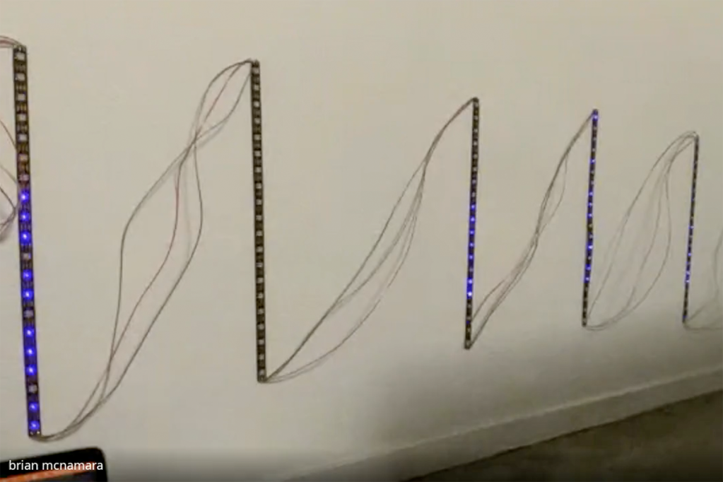 First of two images, this one being LED light strips on a wall showing blue lights indicating different frequencies in a soundtrack.